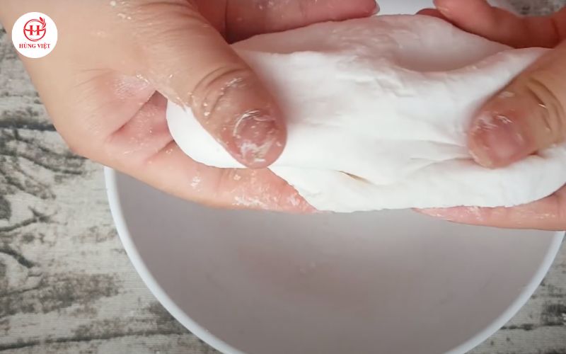 Đổ từng thìa nước nóng vào bột