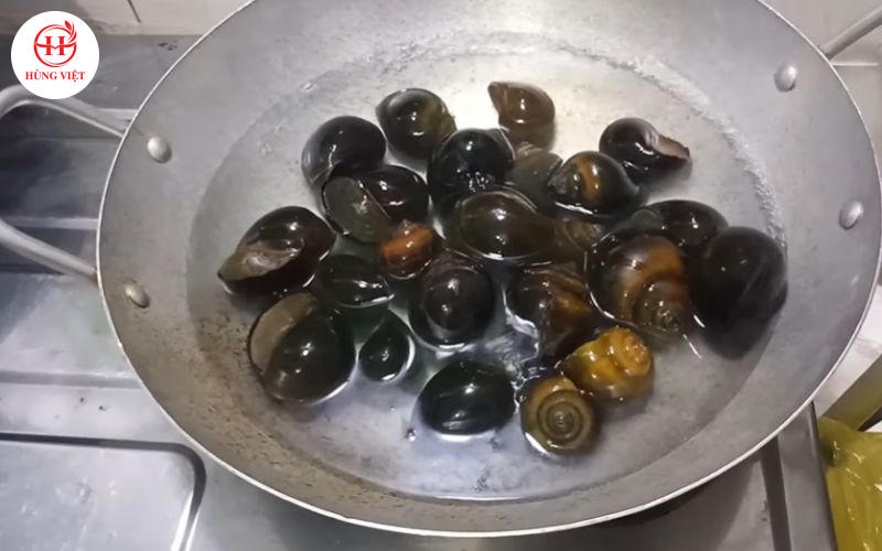 Trụng qua ốc với nước sôi.